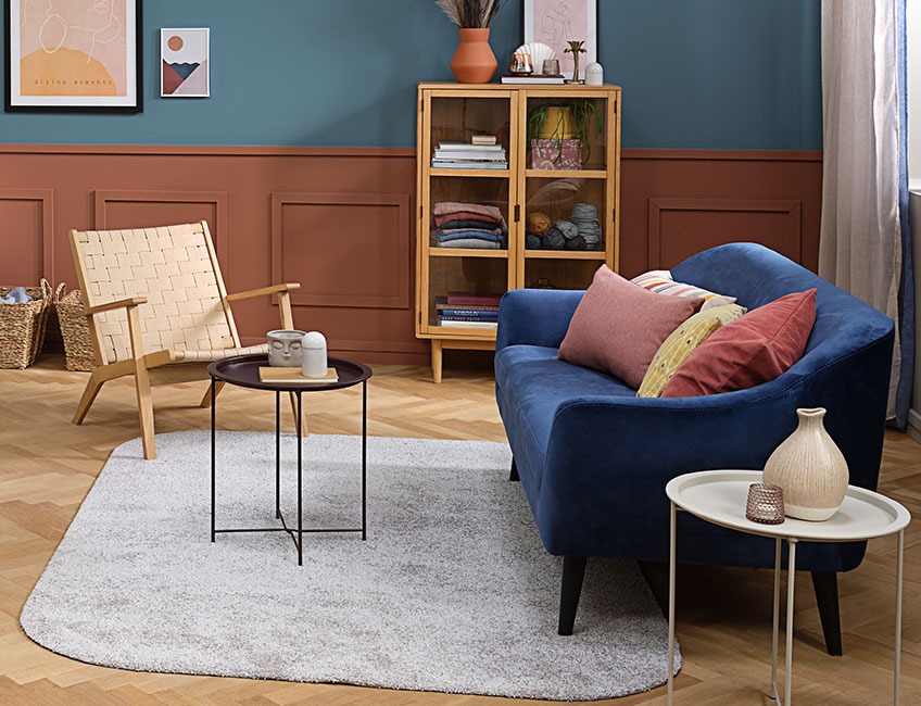 VILLEPLE rug with rounded corners in a living room with VADEHAVET armchair (in stores December 1st 2020) and the blue EGEDAL sofa Living room with a light grey rug, an armchair and a sofa with colourful cushions