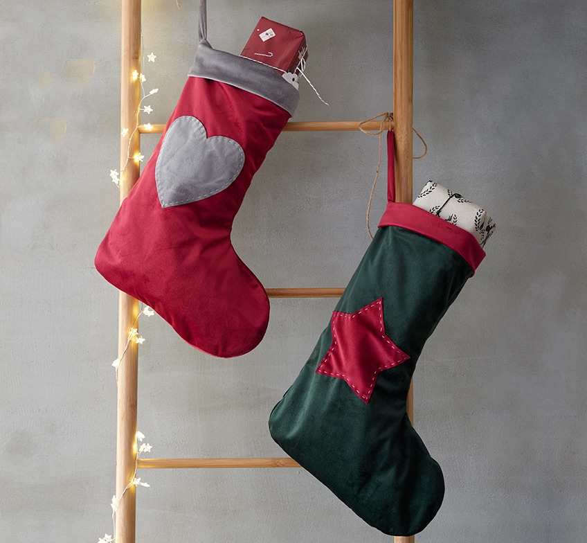 Kerstsokken in rood en groen op een decoratieve ladder
