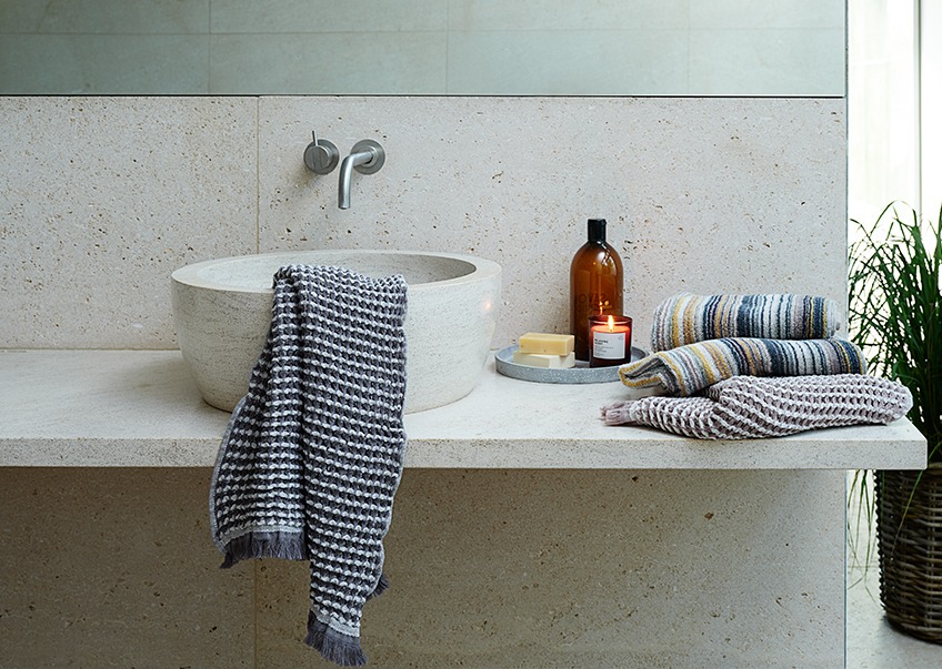 Handdoeken en gastendoekjes bij een wastafel in de badkamer 