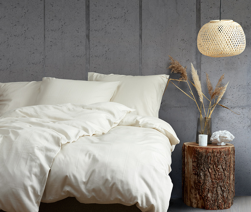 Elegante slaapkamer met een rustige Scandinavische uitstraling en bed met zandkleurig beddengoed 