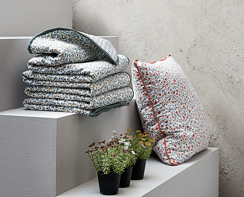 FLORA plaids en sierkussen en KALLE kunstbloemen Trap met gebloemde plaids en een kussen en drie kunstbloemen