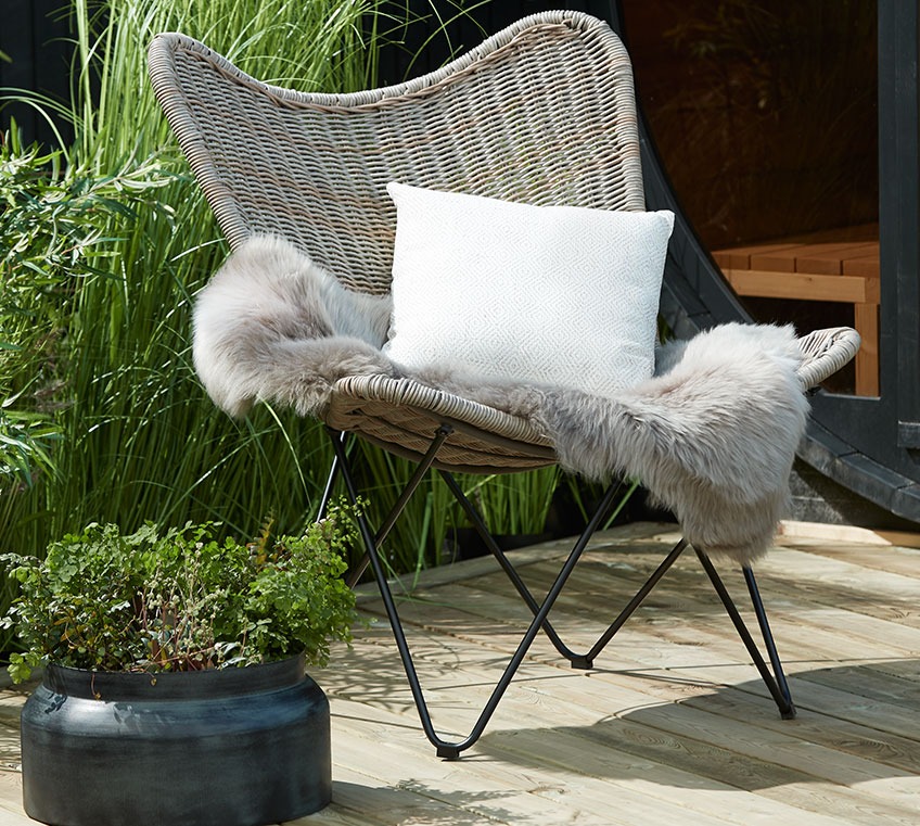 Rotan loungestoel met vacht en sierkussen