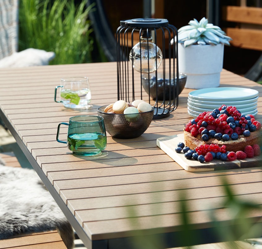 Tuintafel met koekjes, cake en mokken