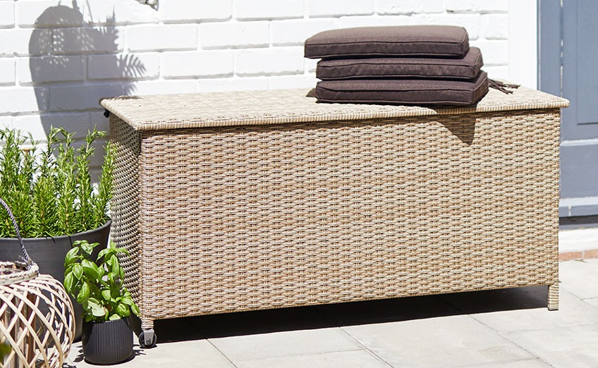 YDERUP kussenbox met wielen en een handvat Kussenbox met handvat en wielen op een zonnig terras