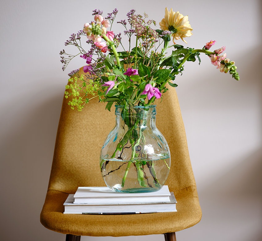 Glass vase on a dining chair  