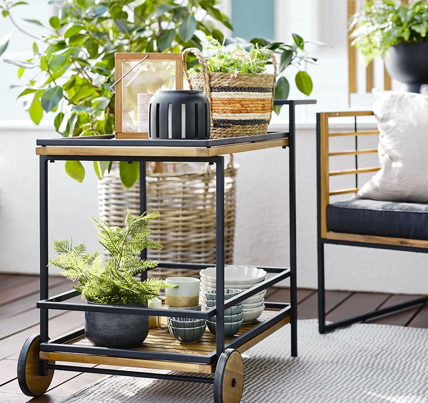 Balkon met trolley, lantaarns, schalen en planten