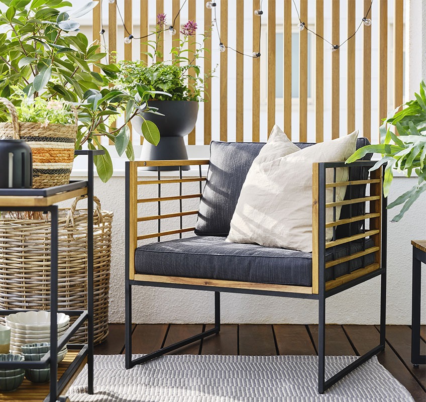 Balcony with lounge chair in wood and black and green plants