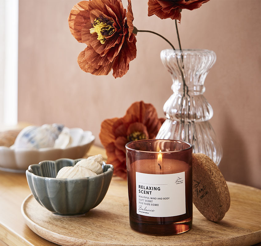 Scented candle and small bowl on wooden tray