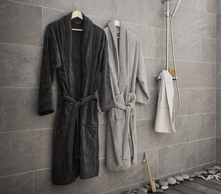 Bathroom with bathrobes, white towel and bath brush