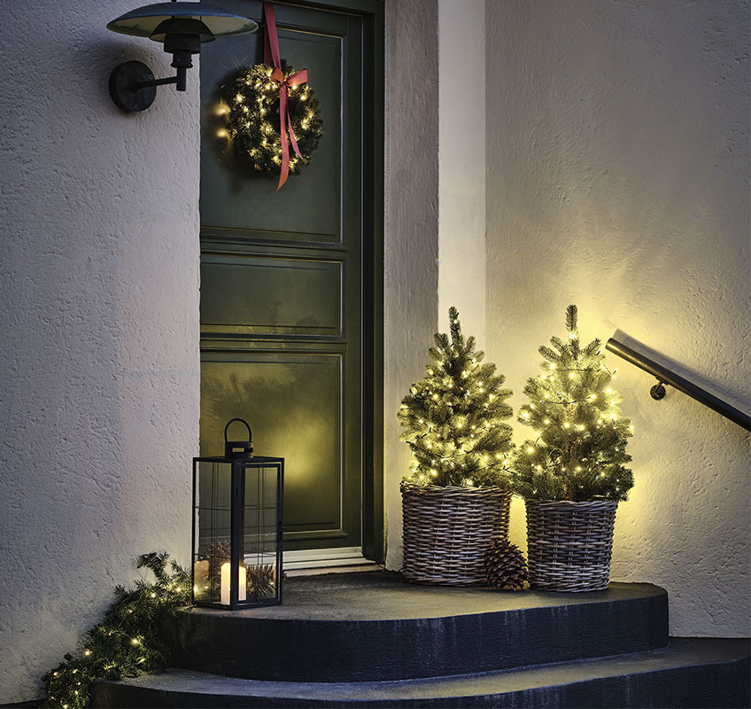 BERLINGER artificial trees, FENRIS wreath and VILLADS lanterns Two lights trees in front of front door and Christmas wreath with red bow