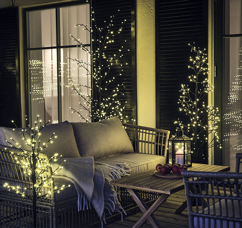 Buiten lampjesbomen op een houten patio met loungeset