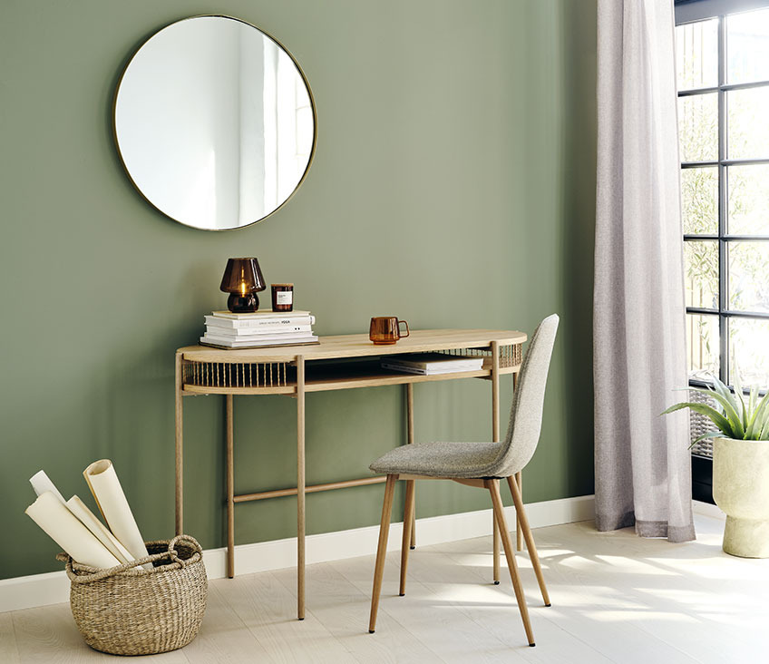 Round mirror above a desk 