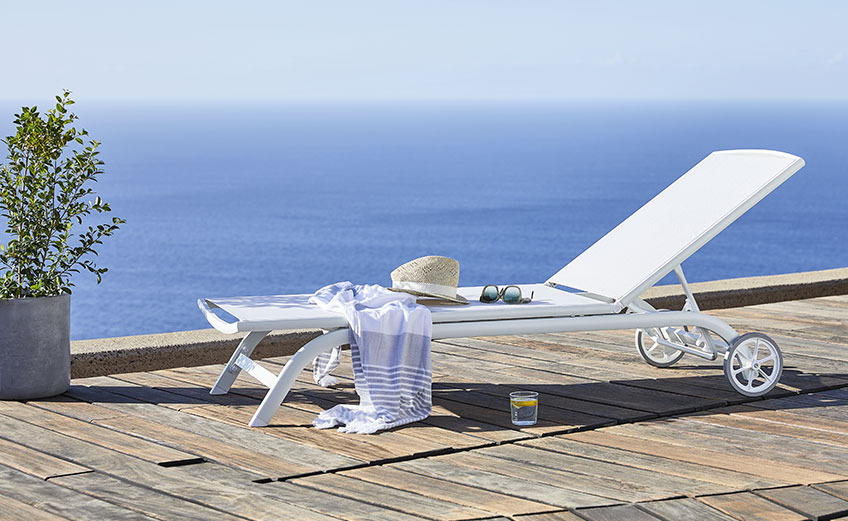 Bain de soleil blanc à roulettes au bord de l'océan