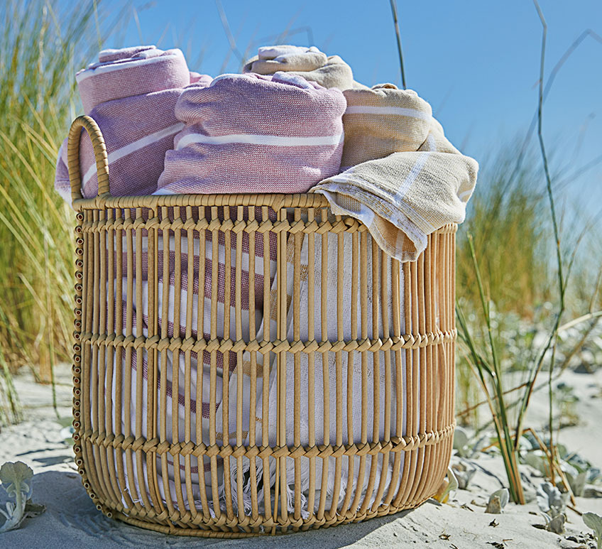 ALVAR mand met BACKA handdoeken Mand met handdoeken op een strand